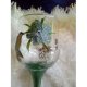 Hand painted kingfisher with flowers and stems in green wine glass